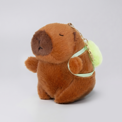 Soft capybara keychain wearing green backpack with a gold keychain