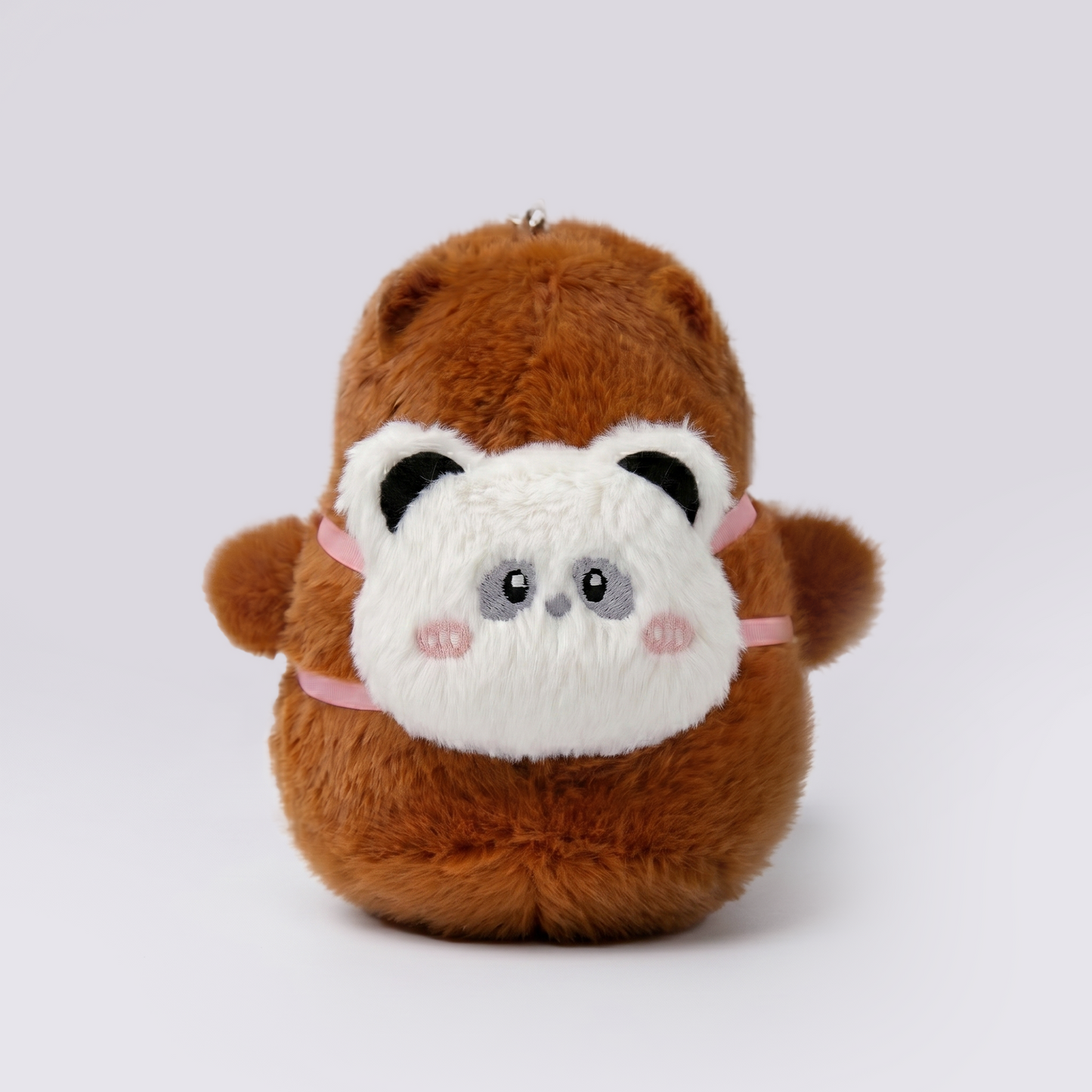 Soft capybara plush keychain wearing a panda plush shaped backpack with pink straps 