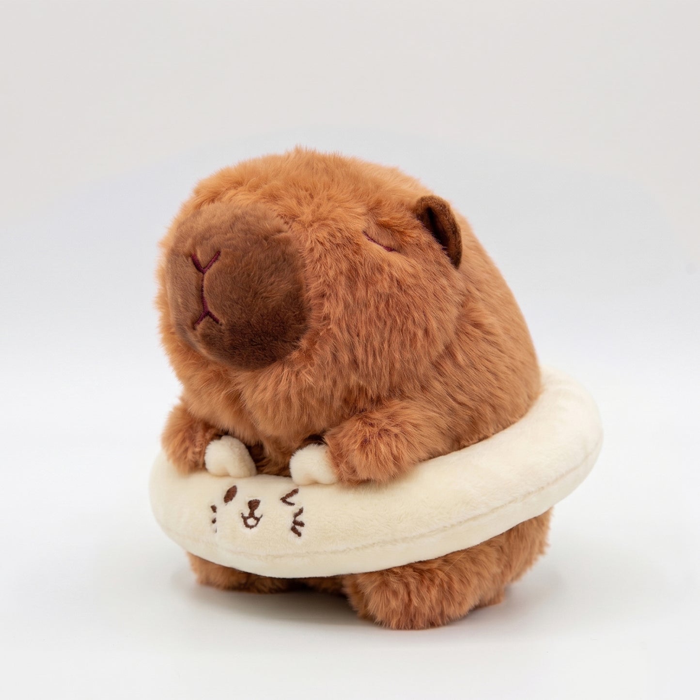 Fluffy capybara plush toy wearing a cream floatie ring
