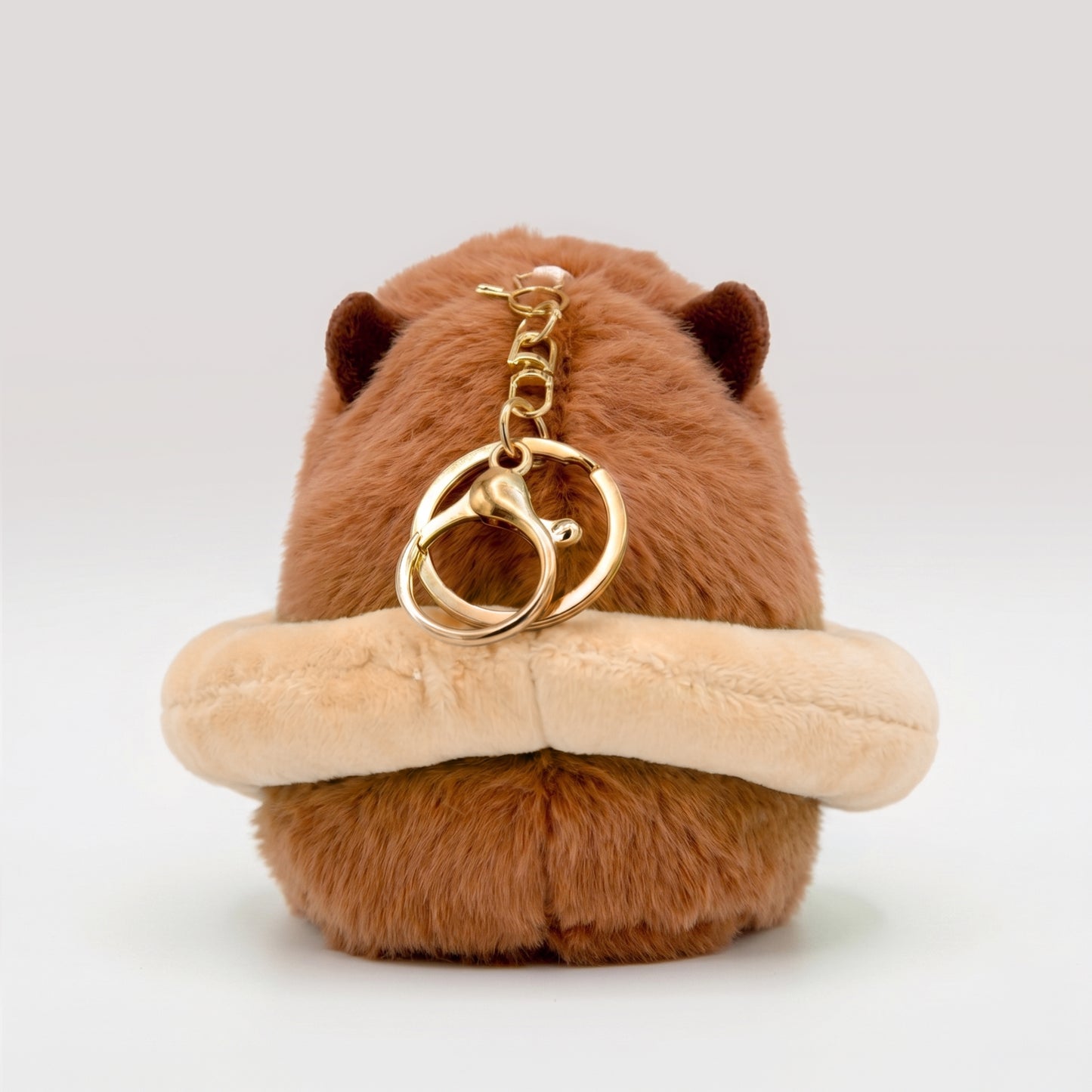 Back view of capybara plush keychain with gold key ring