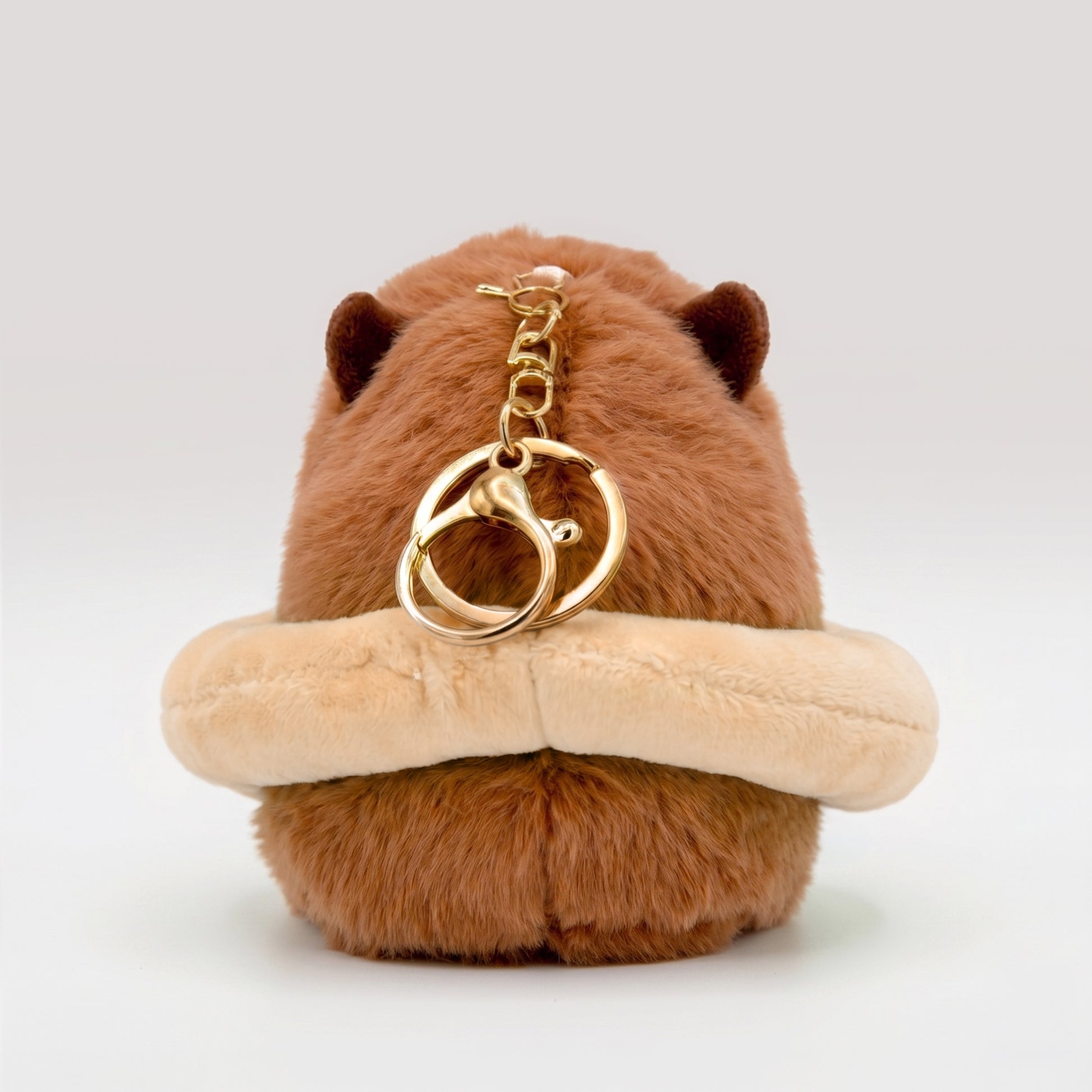 Back view of capybara plush keychain with gold key ring