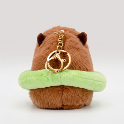 Back view of soft Capybara plush wearing a bright green floatie with a gold key ring keychain