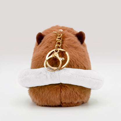 Back view of soft capybara plush wearing a white plush floatie with a gold keyring keychain on a white background