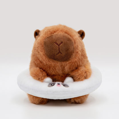 Soft capybara plush wearing a white plush floatie with a panda face on a white background